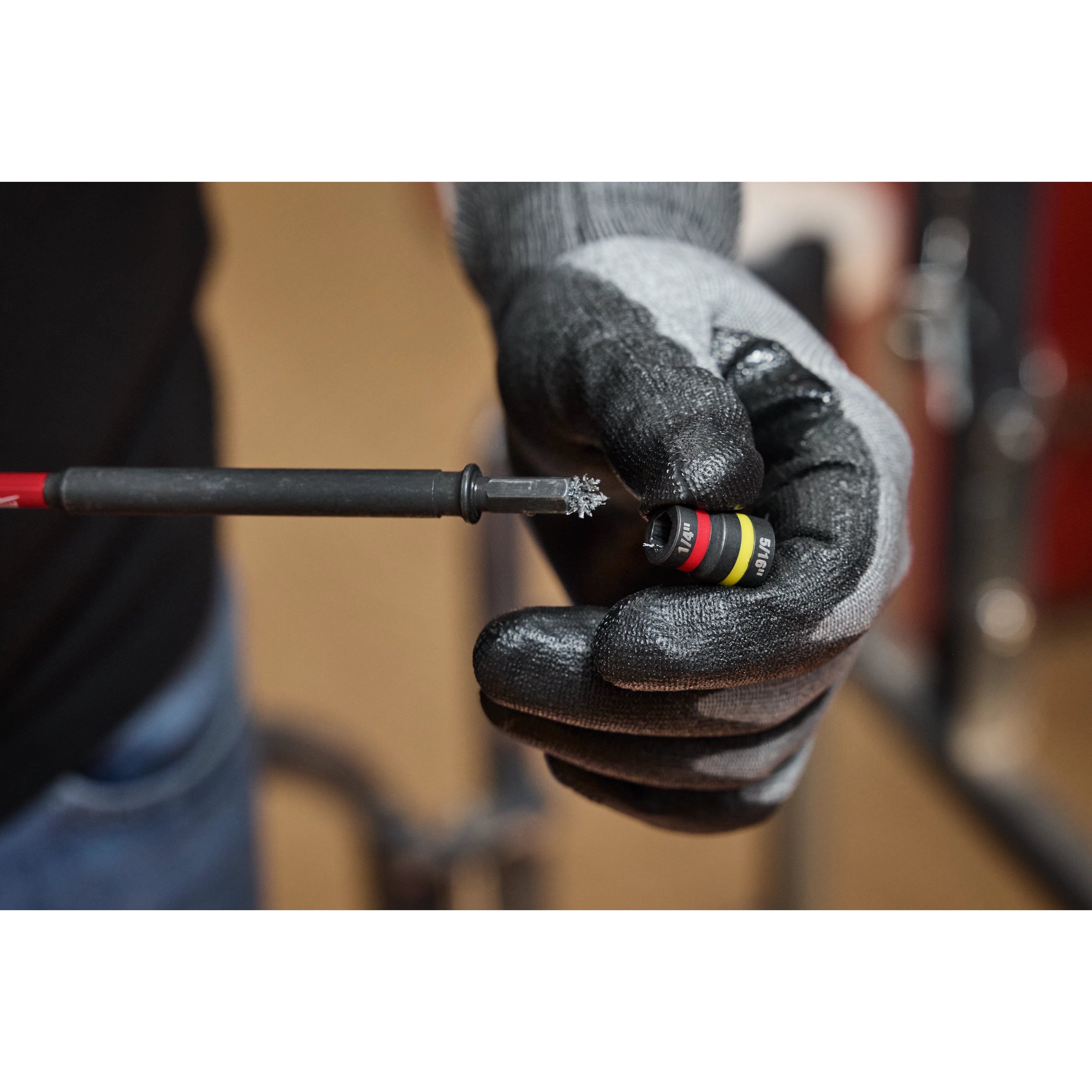 A gloved hand holds the SHOCKWAVE™ Impact Duty 1/4” and 5/16” x 6” QUIK-CLEAR™ 2-in-1 Magnetic Nut Driver.