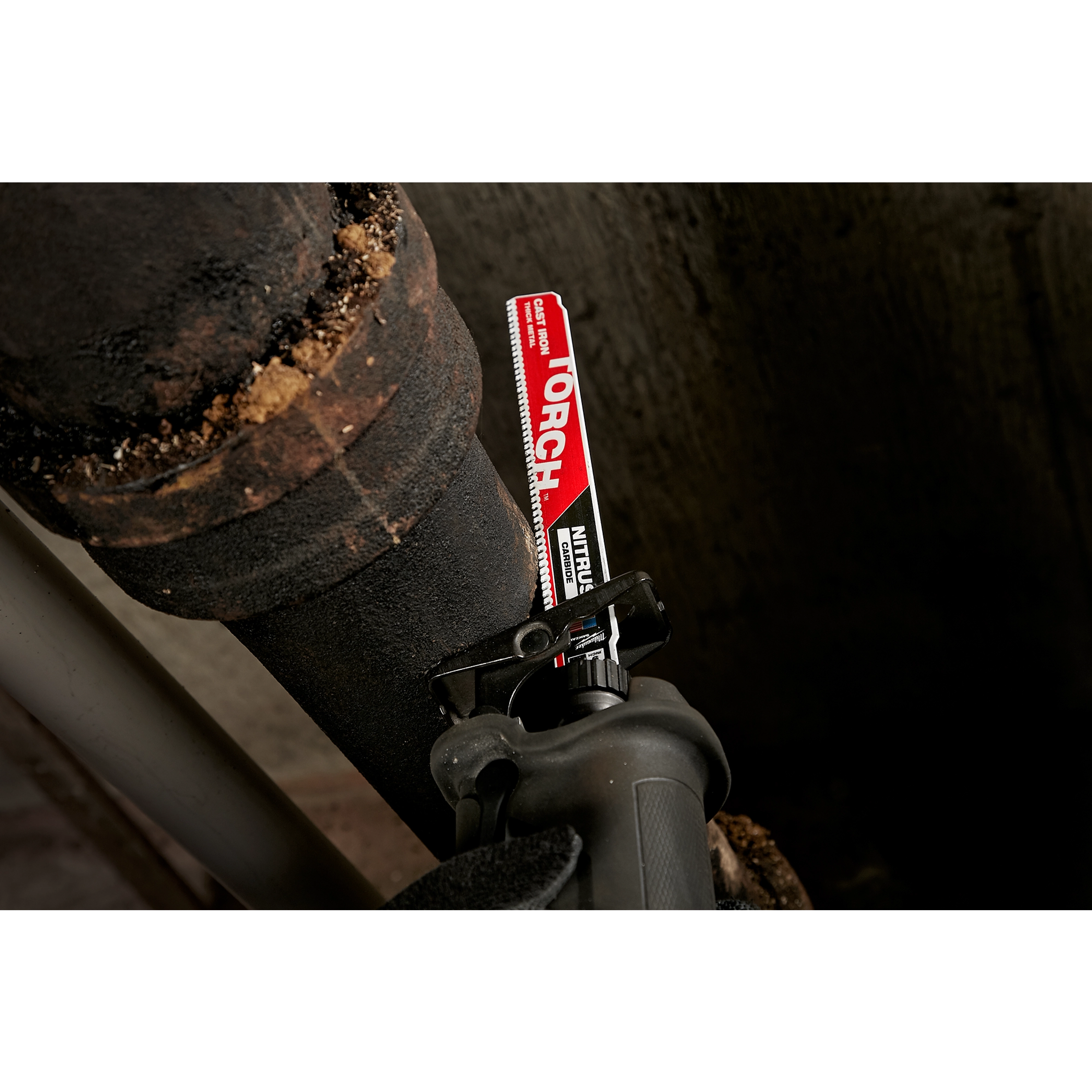 The Milwaukee 9" Cast Iron, Torch w. Nitrus Carbide Sawzall Blade is shown cutting through a thick, rusted iron pipe with ease.