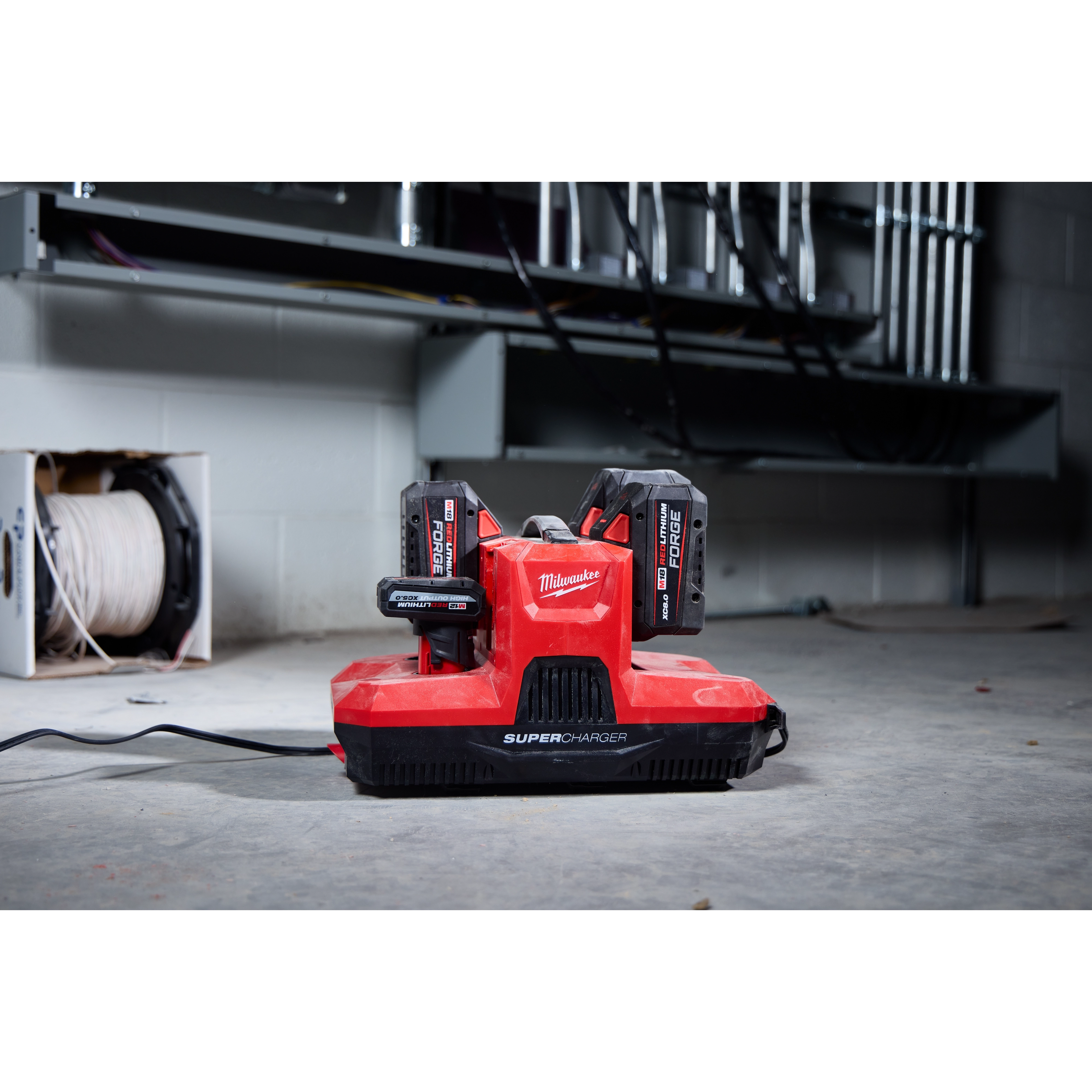 M18 & M12 Four Bay Simultaneous Super Charger with PACKOUT Compatibility charging two batteries in a workshop setting.