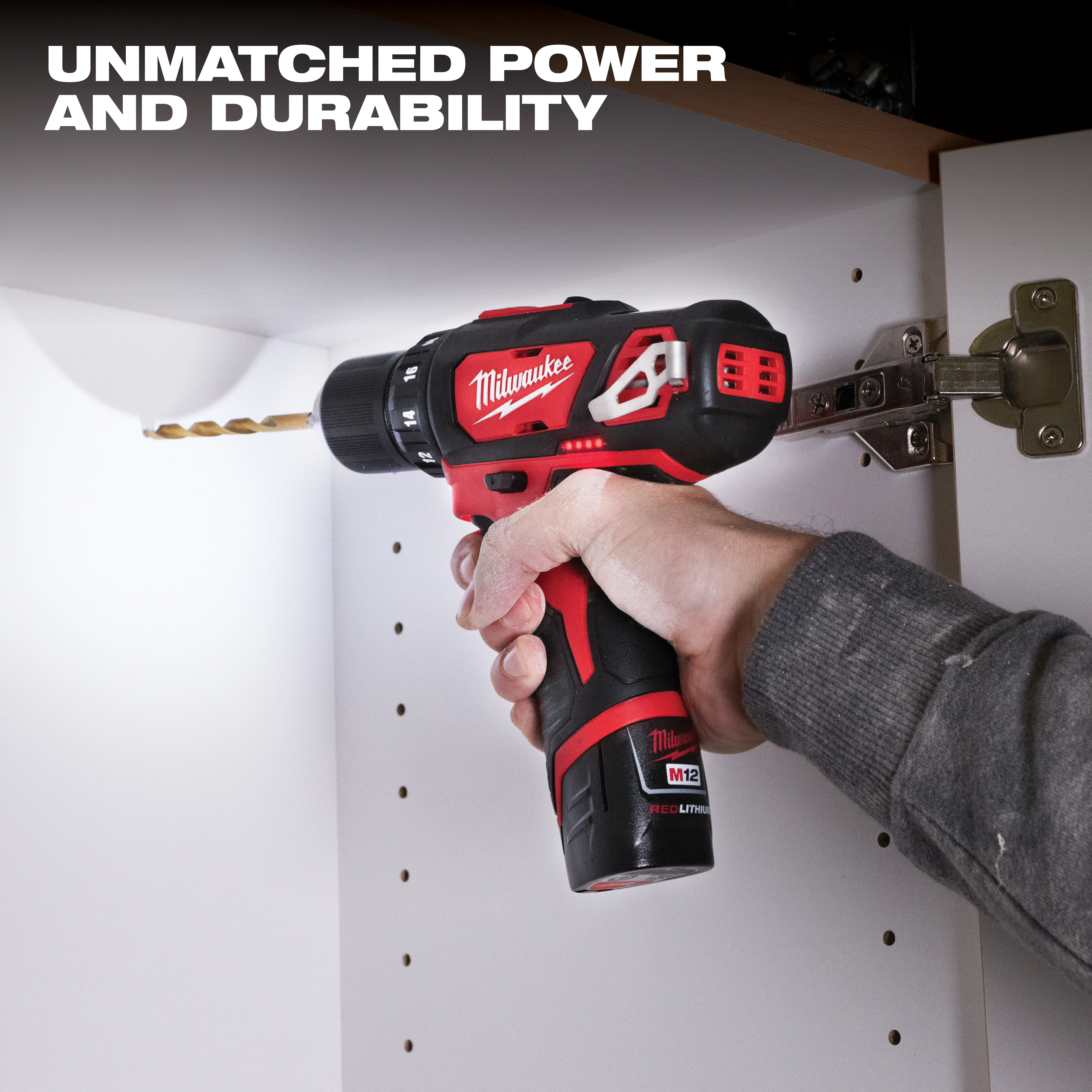 A person is using a red and black drill from the M12 Cordless LITHIUM-ION 4-Tool Combo Kit to drill into a white cabinet.