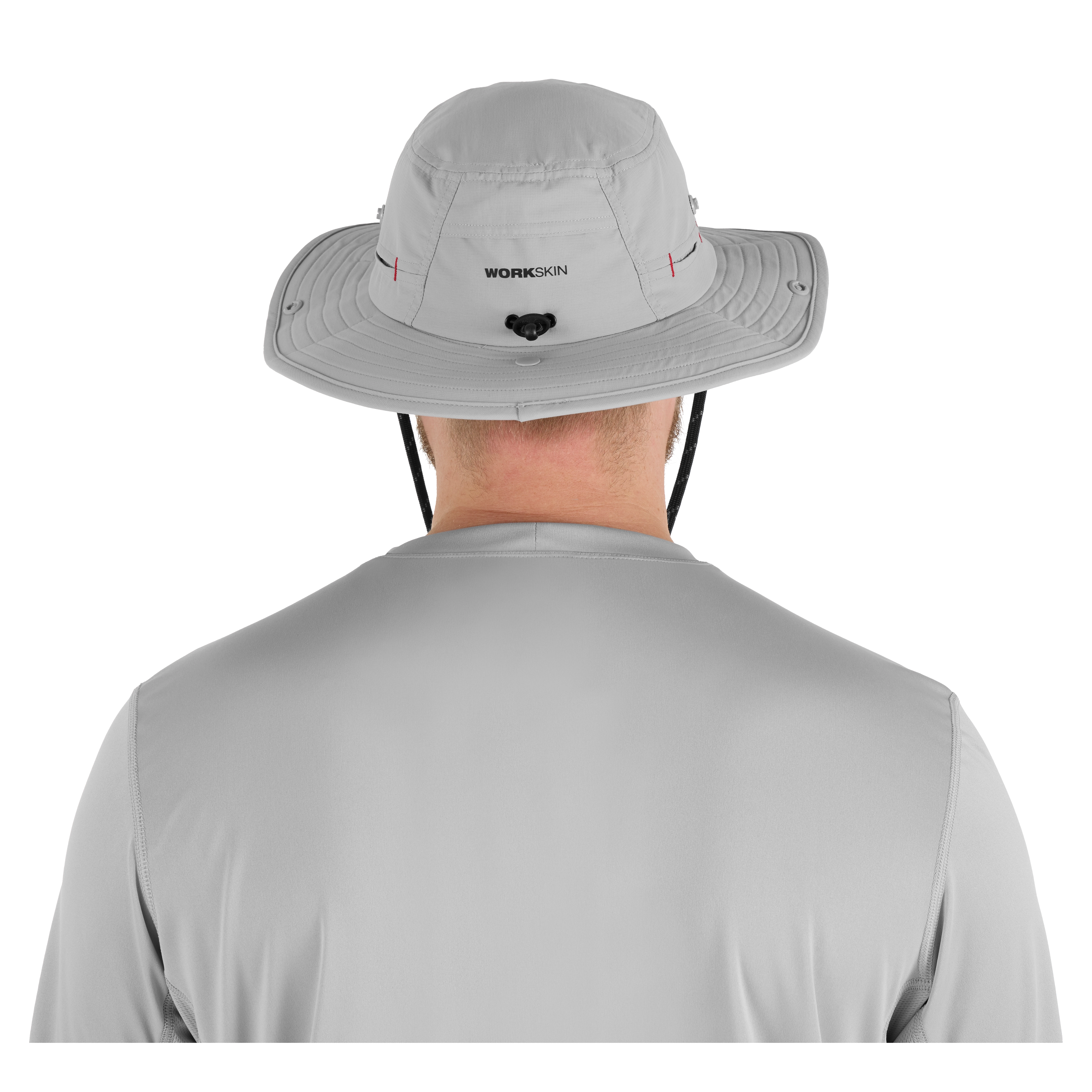 A person wearing a light gray WORKSKIN Sunshade Hat is shown from behind. The hat features a wide brim, adjustable chin strap, and ventilation holes.