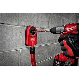 Hammer drill with a 1/2" X 10" X 12" hammer drill bit drilling into a concrete wall, with a dust extractor attached.