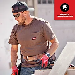 A worker wearing a brown GRIDIRON Pocket T-Shirt - Short Sleeve with visible chest pocket logo, gloves, hat, and tool belt.