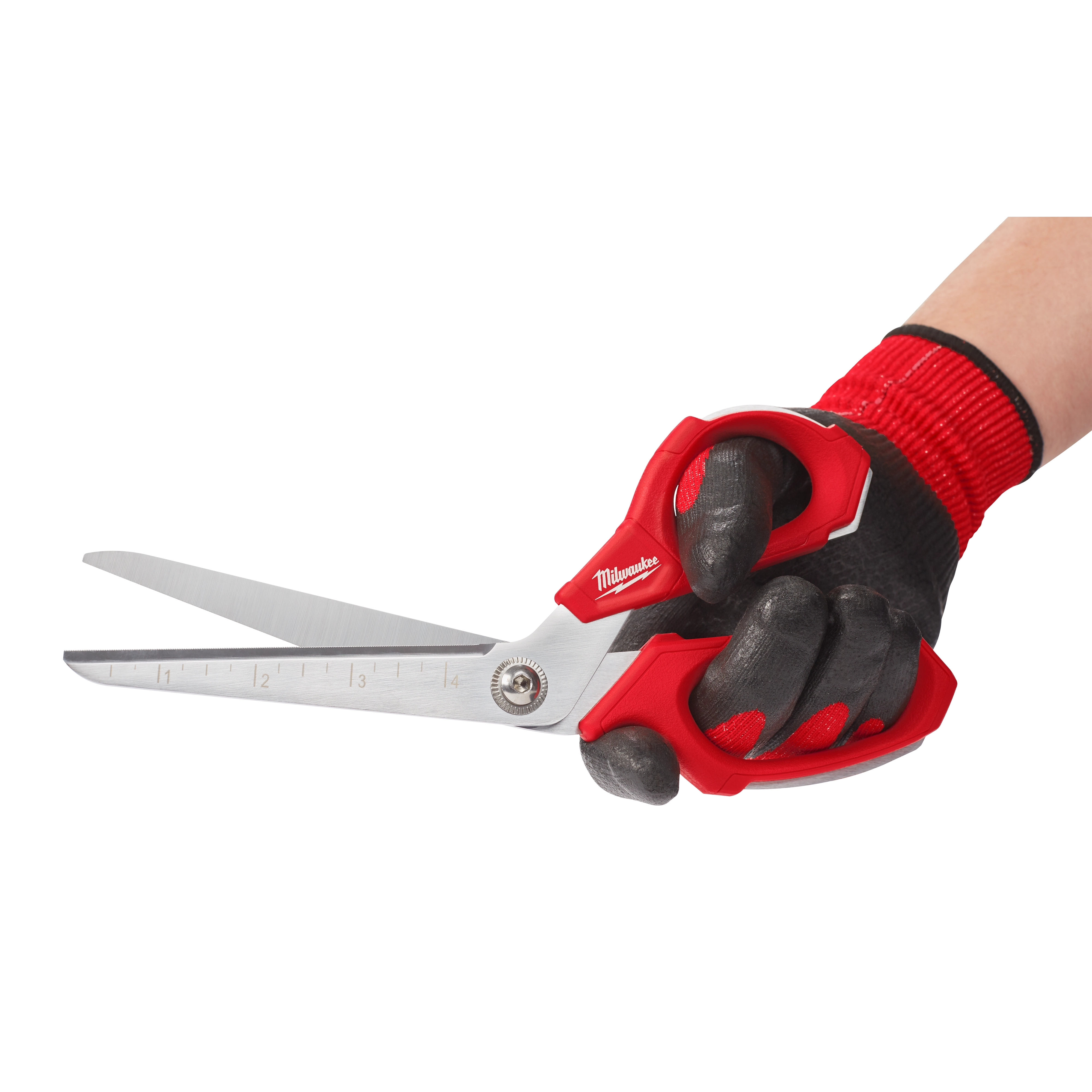A hand wearing a black and red work glove is holding Offset Jobsite Scissors with red handles. The blades are silver with measurement markings along one edge.