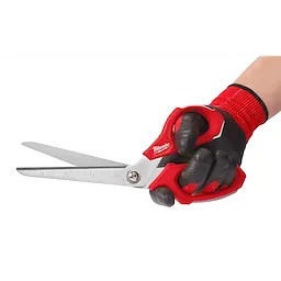 A hand wearing a black and red work glove is holding Offset Jobsite Scissors with red handles. The blades are silver with measurement markings along one edge.