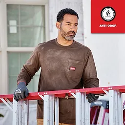 Person wearing a GRIDIRON Pocket T-Shirt - Long Sleeve Anti-Odor stands outdoors, holding a red and silver ladder.