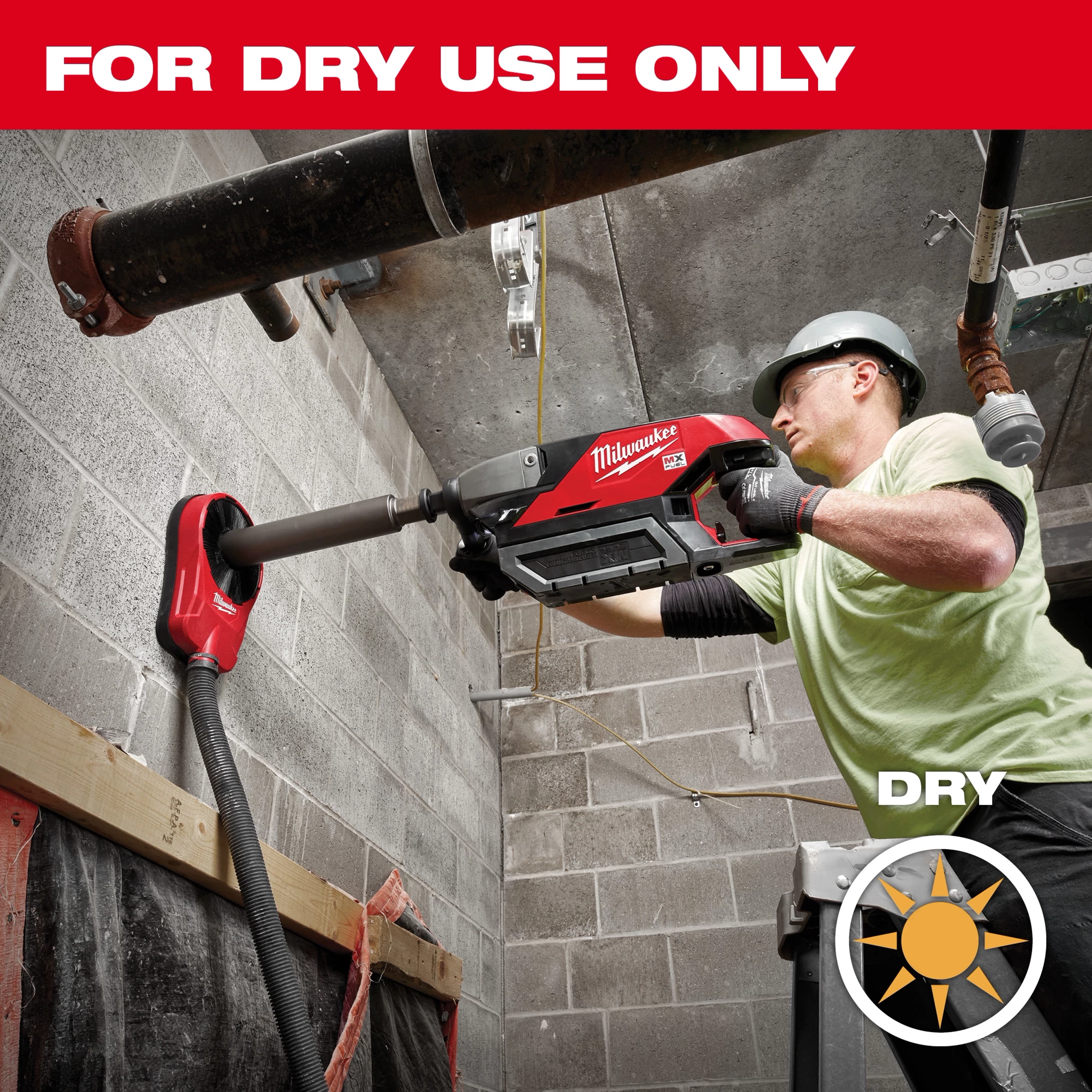 Worker using a power drill with a Diamond Ultra Dry Core Bit For Dry Use Only to bore into a concrete wall indoors.