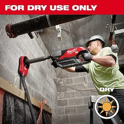 Worker using a power drill with a Diamond Ultra Dry Core Bit For Dry Use Only to bore into a concrete wall indoors.