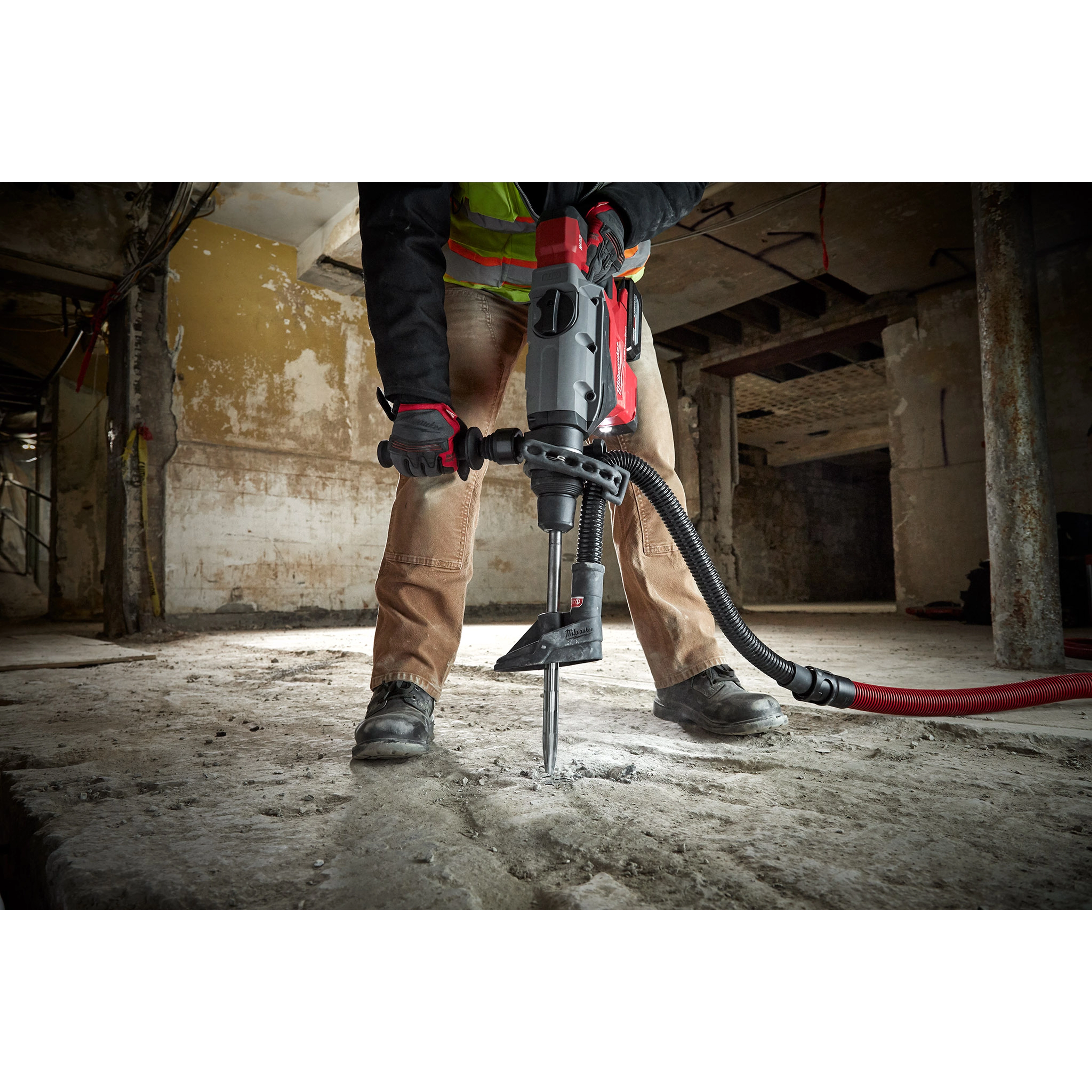 Worker using the SDS-MAX SLEDGE 16" BULL POINT Chisel on a concrete floor, demonstrating its effectiveness for heavy-duty demolition.
