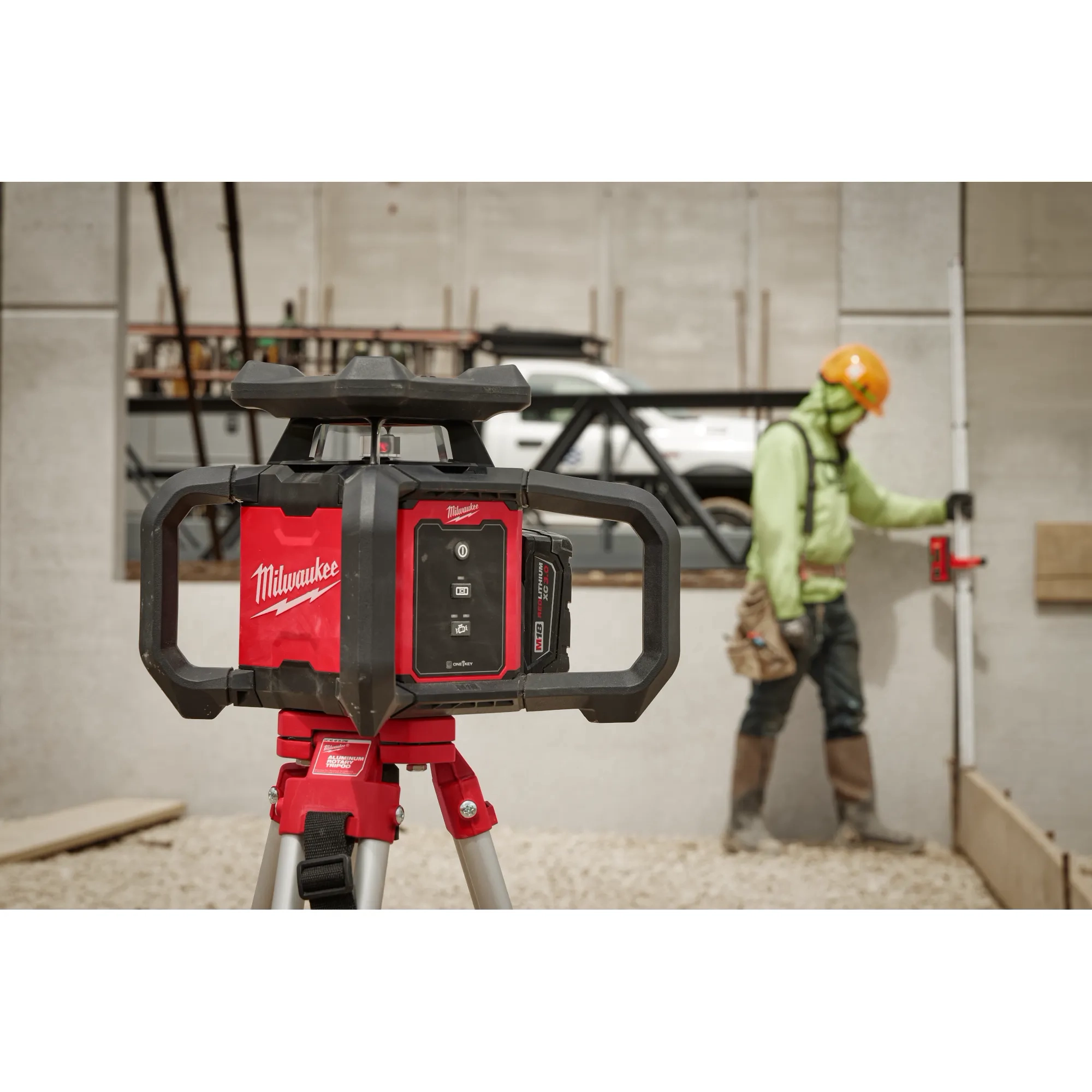 Worker using the Red Exterior Rotary Laser Level on the tripod