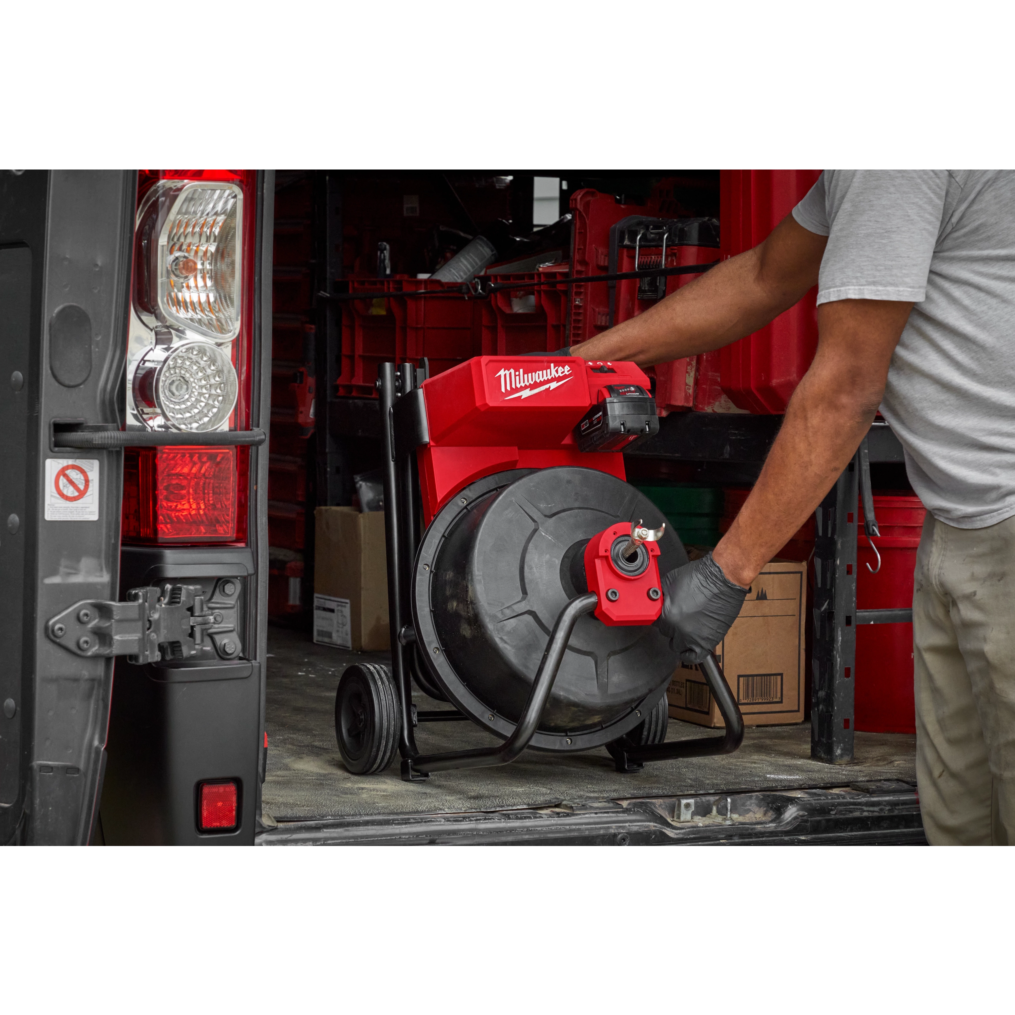 Man easily  putting the M18 Drum Machine in a work truck