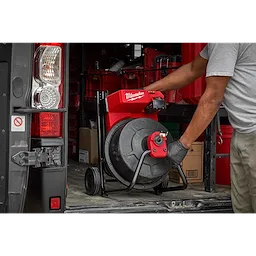 Man easily  putting the M18 Drum Machine in a work truck