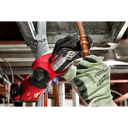 A person using RLS ACR Press Jaws for M18 FORCE LOGIC Press Tools to secure copper piping in an industrial setting.