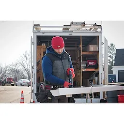 Image of a man on a jobsite wearing the Milwaukee Rib-Knit Cuffed Beanie in red