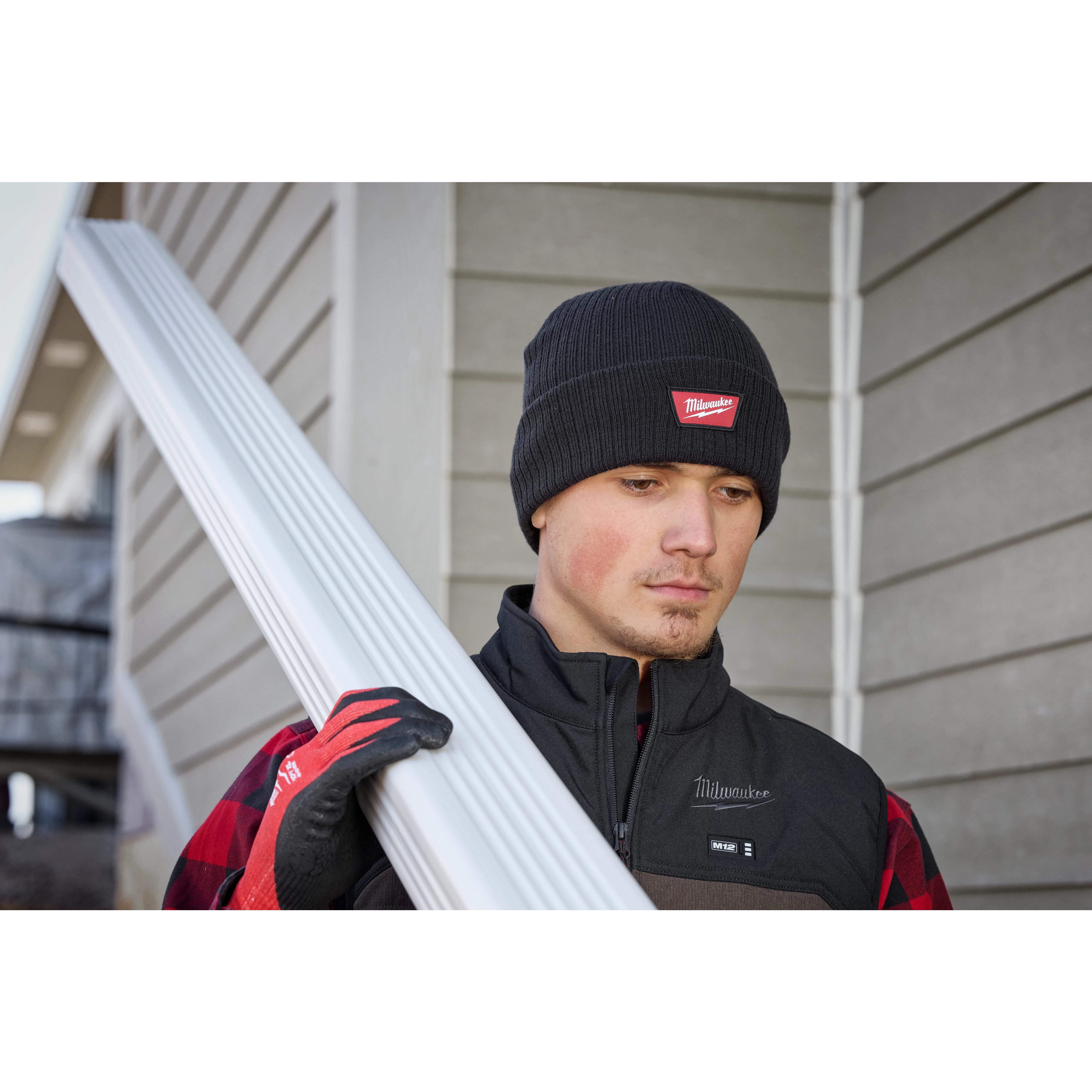 Image of a man on a jobsite wearing the Milwaukee Rib-Knit Cuffed Beanie in black