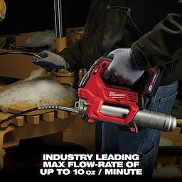 A person in gloves operates a Milwaukee power tool, specifically a cordless grease gun, in a workshop. The text at the bottom reads, "INDUSTRY LEADING MAX FLOW-RATE OF UP TO 10 oz / MINUTE." Snow is visible on the equipment being serviced.