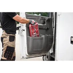 A person in workwear is placing a package of 5/32” Round File for Saw Chain 6 PK inside a truck's door compartment.