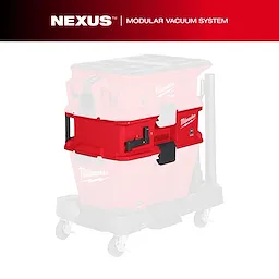 The NEXUS™ Dedicated Filter Cleaner is part of the modular vacuum system by Milwaukee. It is displayed in red with Milwaukee branding, and features handles on both sides. The cleaner is designed to be attached to the main vacuum unit, which is also shown faded in the background.