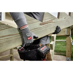 Worker lifting a wooden board while wearing Cut Level 4 High Dexterity Nitrile Dipped Gloves w/ WEAR-DEFENSE Protection.