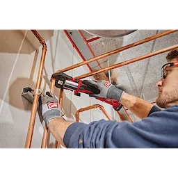 A person uses the 1-1/8" ZoomLock MAX Press Jaw for M18 FORCE LOGIC Press Tools on copper plumbing pipes.