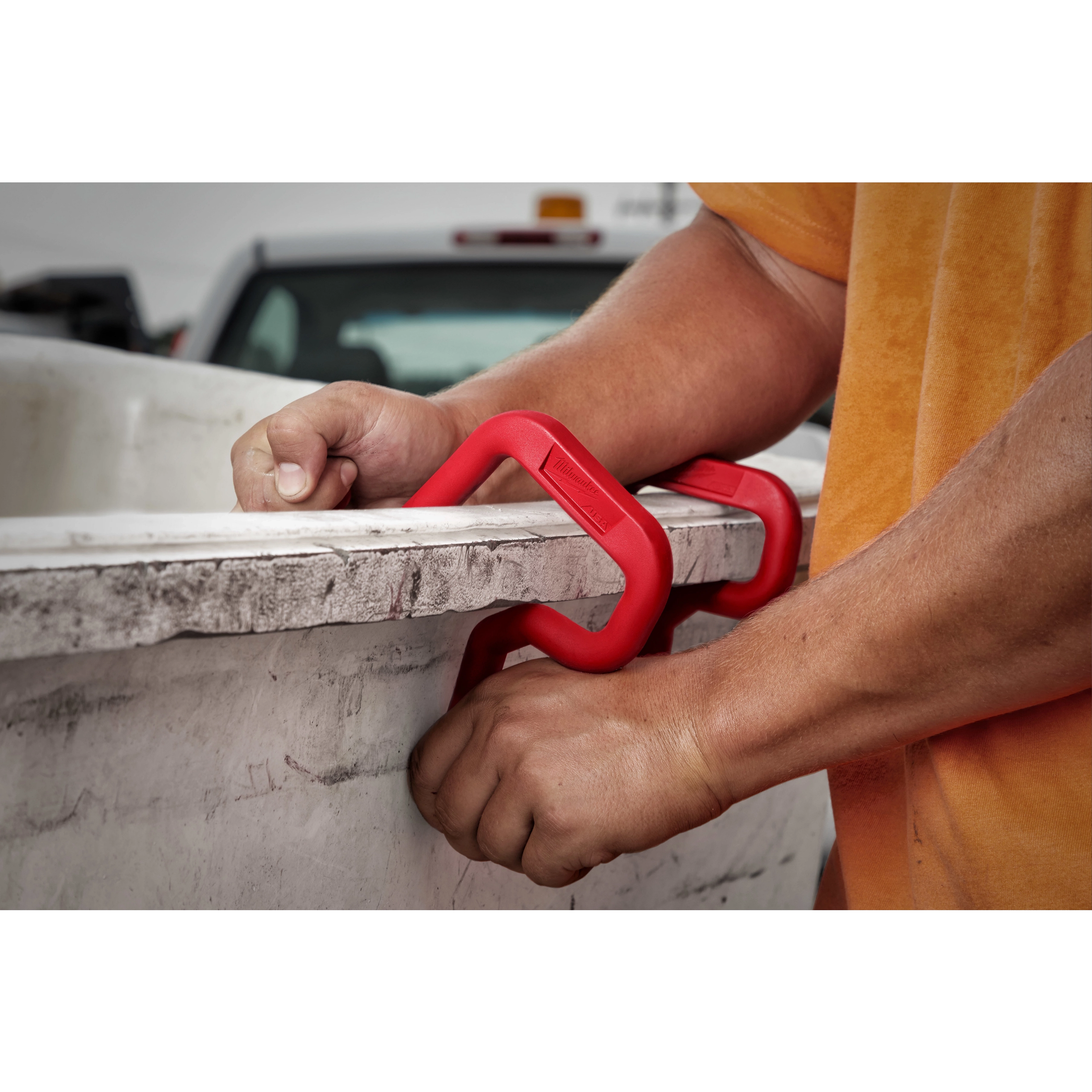 Person attaching a red 3" Bucket Hook to a white container edge with both hands. Another 3" Bucket Hook is seen in the background.