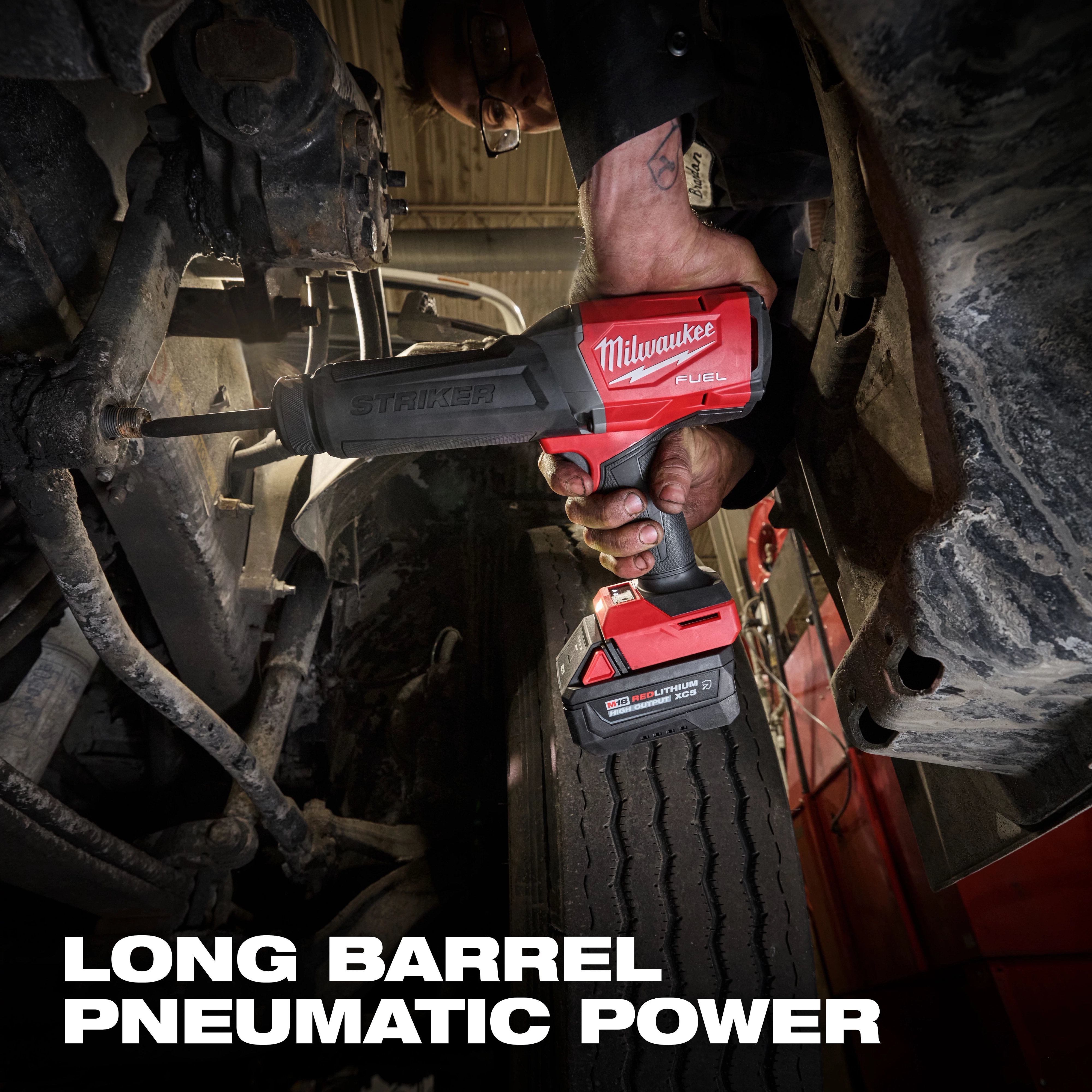 M18 FUEL STRIKER Hammer Chisel in use on vehicle suspension above a large tire.