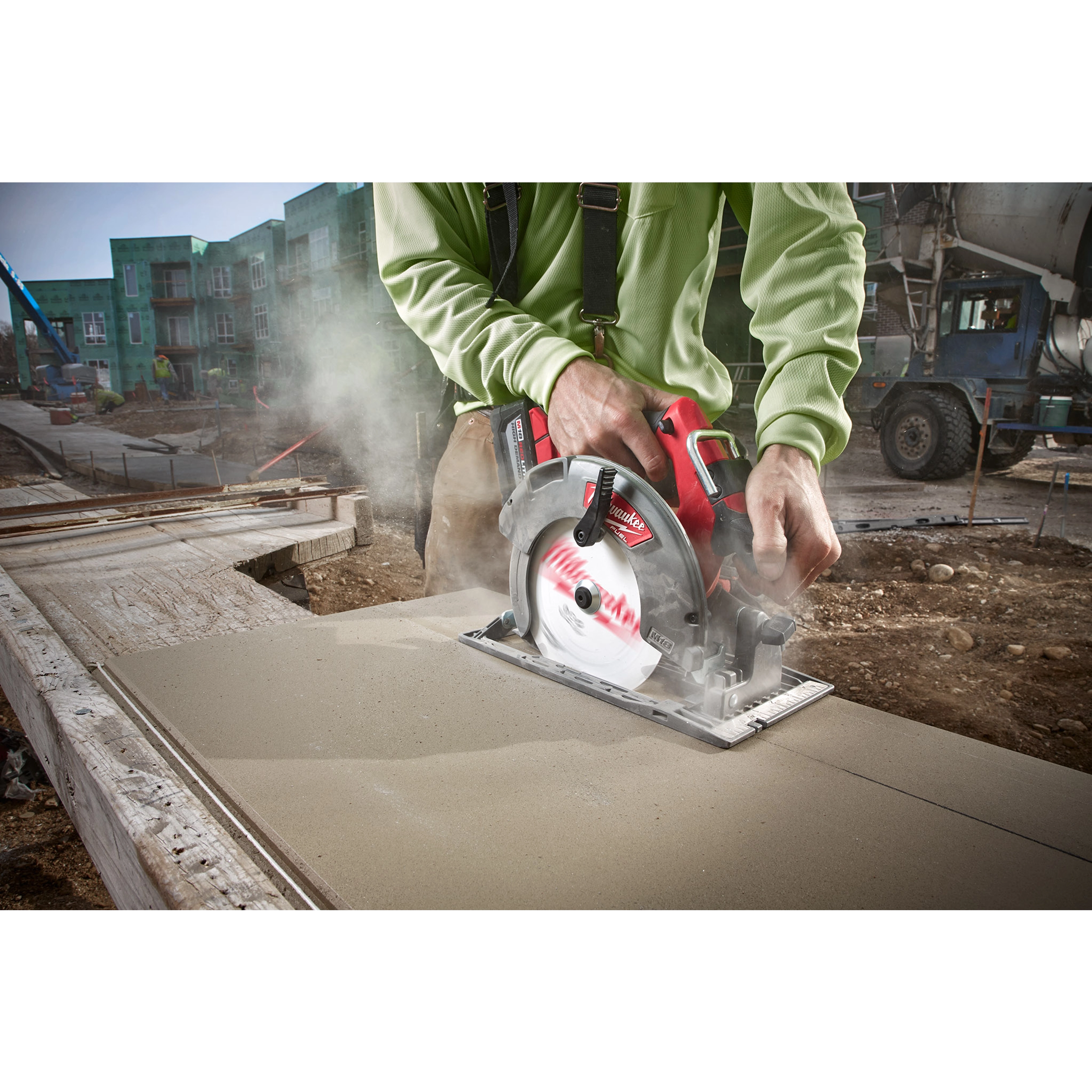 Worker cutting fiber cement board with a circular saw equipped with a 7-1/4" PCD/Fiber Cement Circular Saw Blade at a construction site.