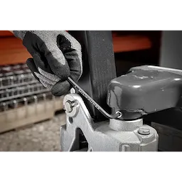 A gloved hand uses an L-key from the 9-Key Ball End L-Key Set - Metric to tighten a bolt on industrial equipment.