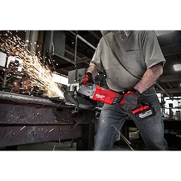 Person using the M18 FUEL 7” / 9” Large Angle Grinder (LAG) to cut metal, producing sparks in an industrial setting.