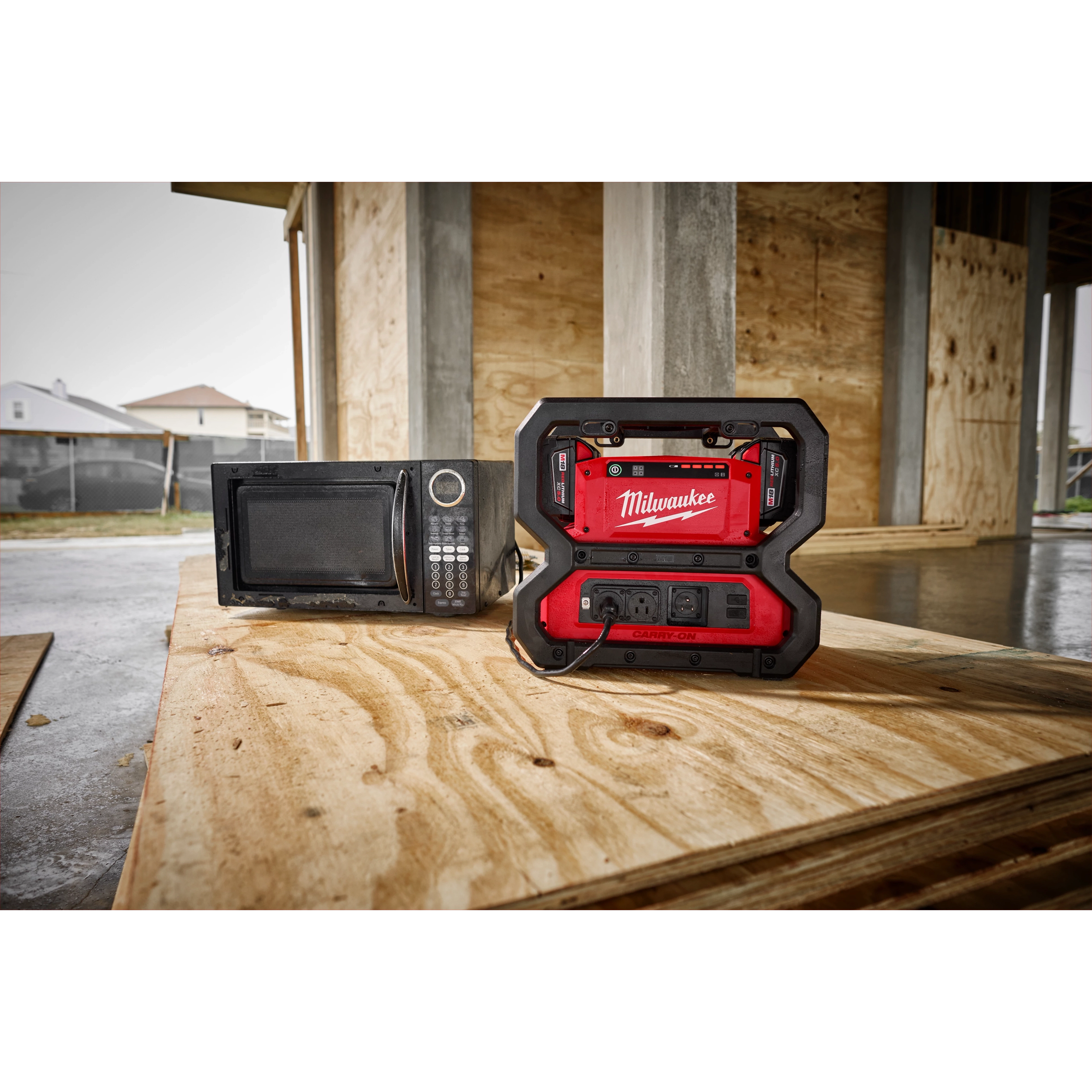 The M18 Carry-On 3600W/1800W Power Supply powering a microwave