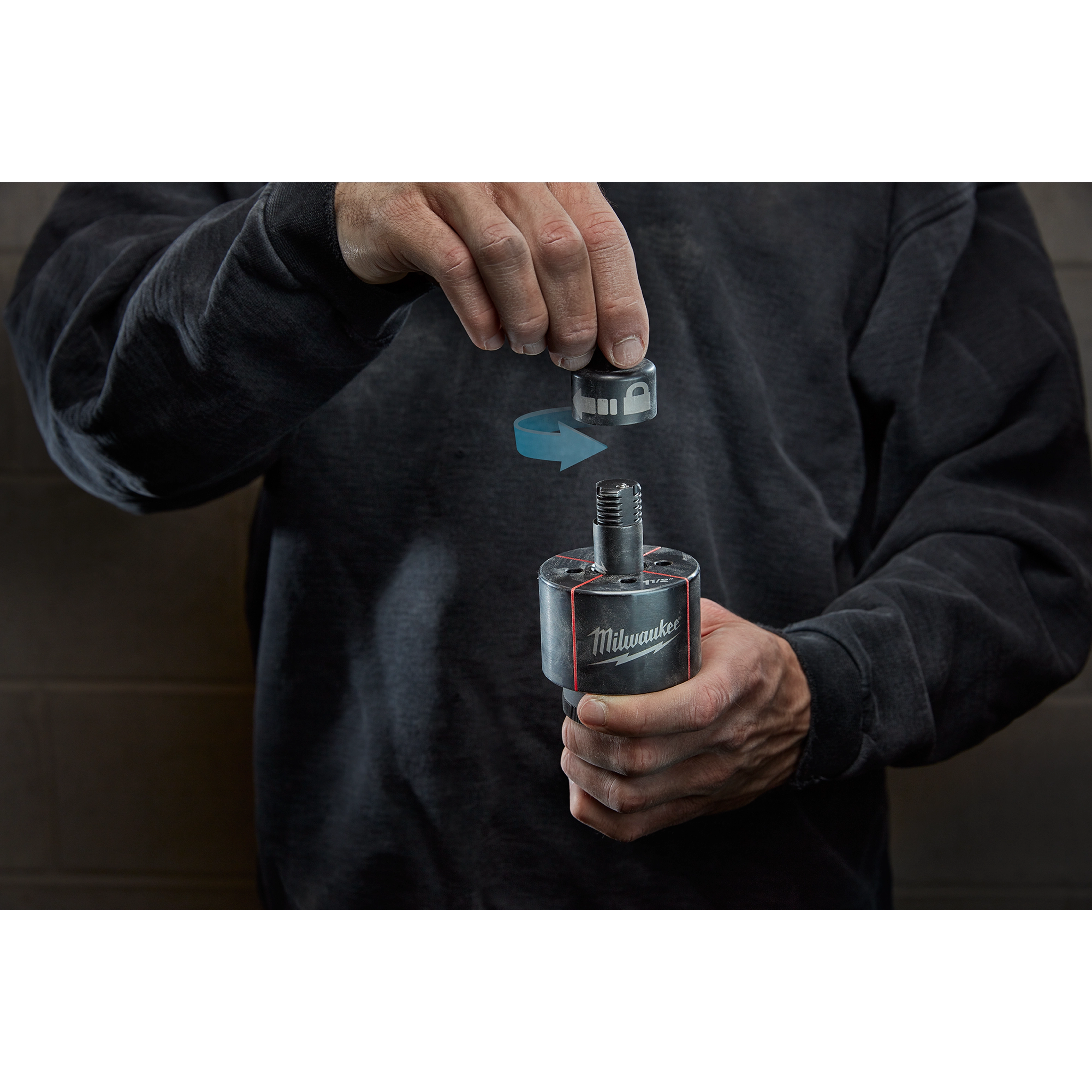 Person holding a Milwaukee Draw Stud, shown with an arrow indicating attachment of parts. The person is wearing a dark sweater.