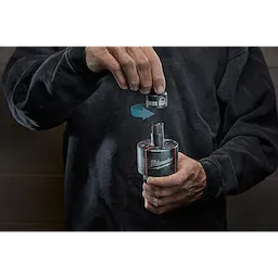Person holding a Milwaukee Draw Stud, shown with an arrow indicating attachment of parts. The person is wearing a dark sweater.
