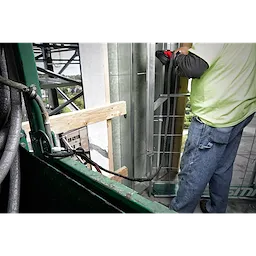 Construction worker using a 15LBS 72" Extended Reach Locking Tool Lanyard, secured to a basket while working on a high-rise structure.