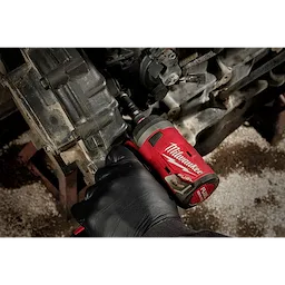 A person uses a red Milwaukee FUEL tool with a SHOCKWAVE Impact Duty 1/4" Drive 14MM Deep 6 Point Socket to work on a vehicle engine.