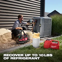 Technician using an M18 Brushless Refrigerant Recovery Machine next to an HVAC unit.
