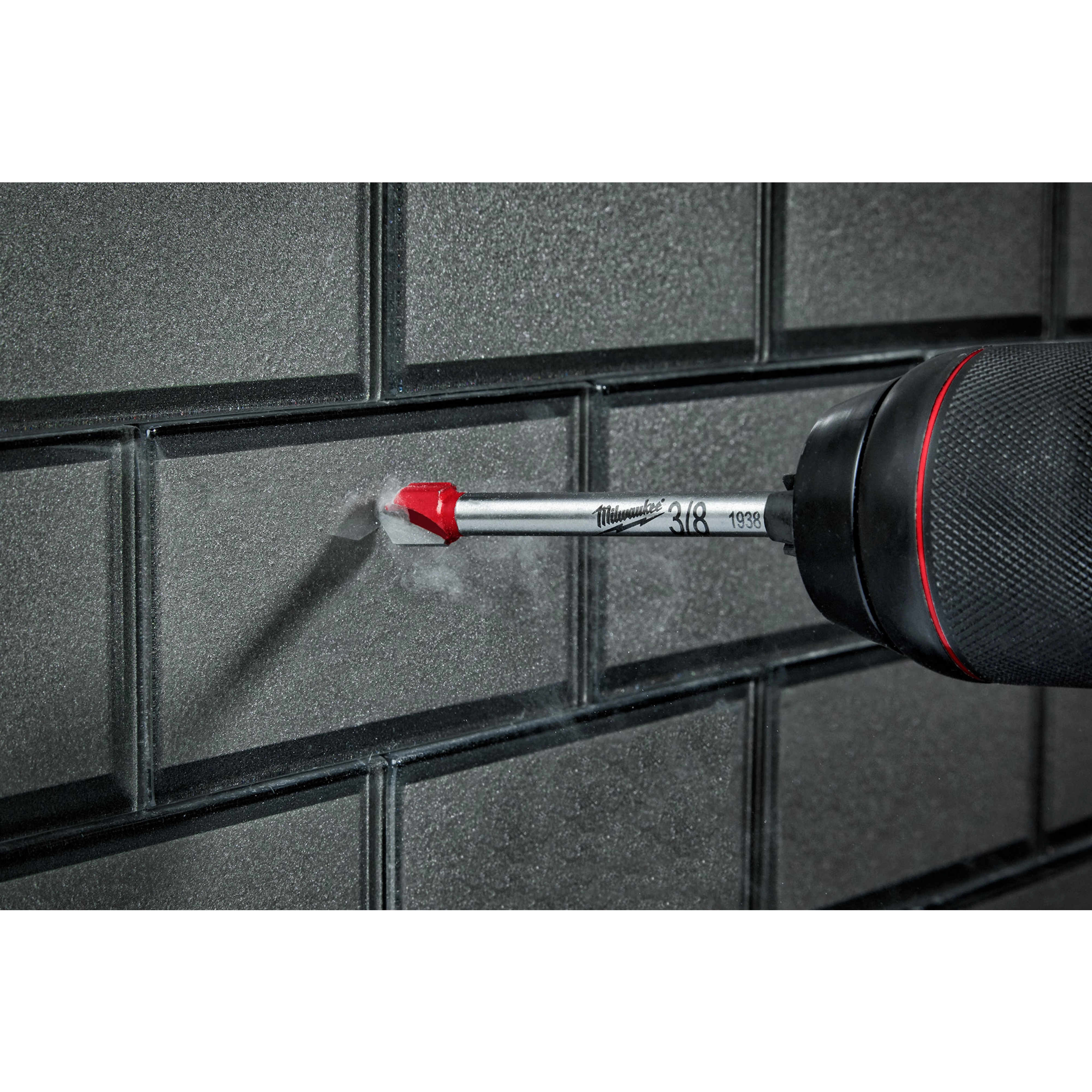 3/8" Glass and Tile Bit drilling into a gray tile wall. The drill bit has a red-tipped point and a silver shaft.