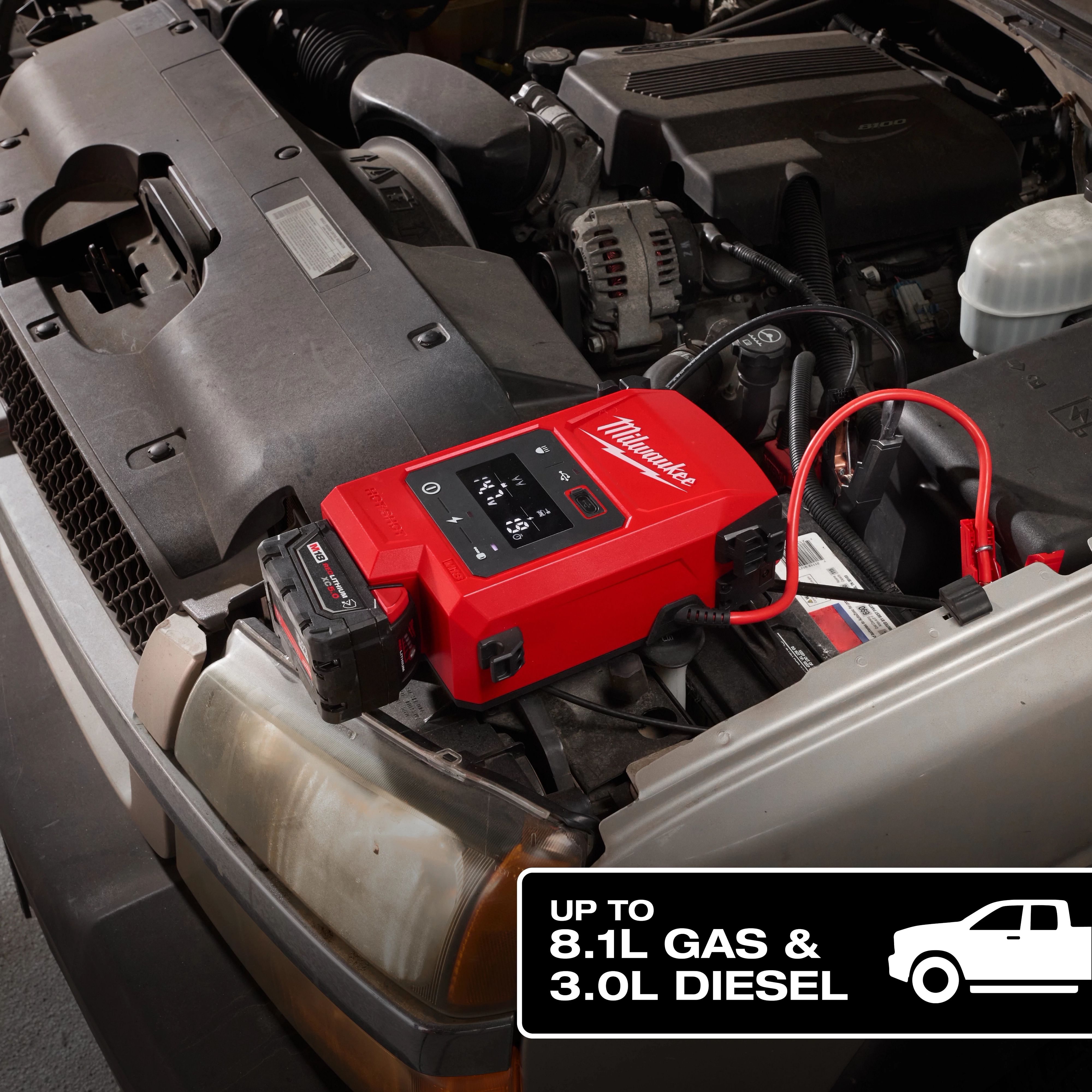 The M18™ HOTSHOT™ Jump Starter is connected to the battery of a vehicle with its hood open. A label in the corner indicates the jump starter's capacity, up to 8.1L gas and 3.0L diesel engines.