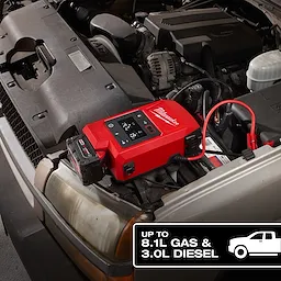 The M18™ HOTSHOT™ Jump Starter is connected to the battery of a vehicle with its hood open. A label in the corner indicates the jump starter's capacity, up to 8.1L gas and 3.0L diesel engines.