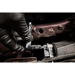 A gloved hand uses the 1/4" Drive T20 Tamper Proof TORX Bit Socket to tighten a bolt in a mechanical setting.