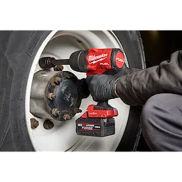 M18 FUEL 3/4" Extended Anvil High Torque Impact Wrench w/ ONE-KEY loosening lug nuts on a large vehicle wheel.