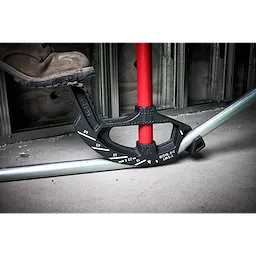 1" EMT Iron Conduit Bender being used to bend a metal conduit pipe. A worker’s boot is applying pressure on the bender.