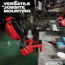 M18 Brushless Scissor Lift Fan mounted on the edge of a workbench in an industrial setting.