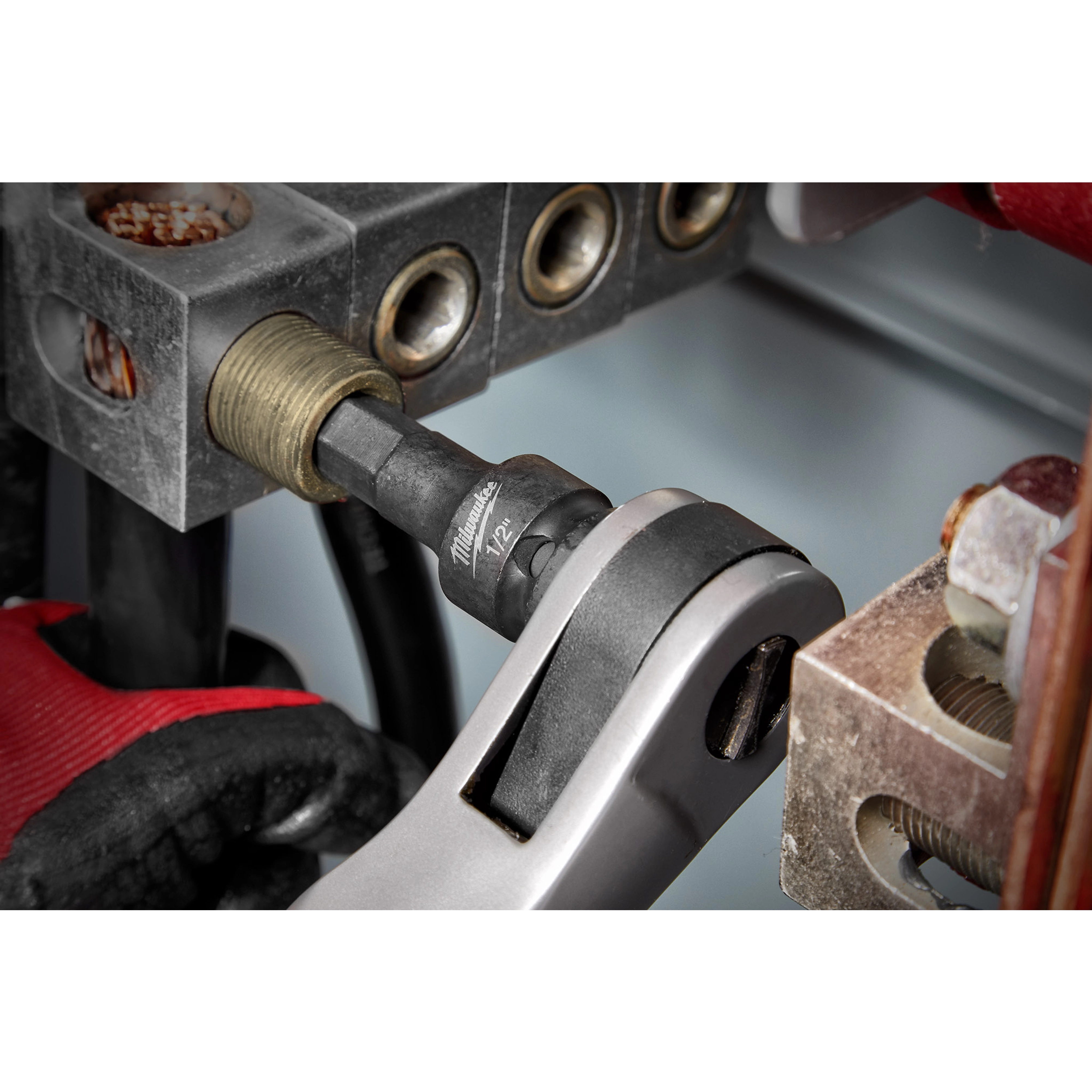 1/2" Drive 1/2" Hex Bit Socket attached to a socket wrench in use, tightening a hex bolt in an industrial machinery setting.