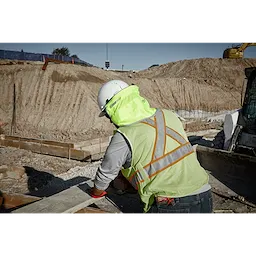 Worker wearing the BOLT Sunshade attached to a hard hat while working outside on the jobsite
