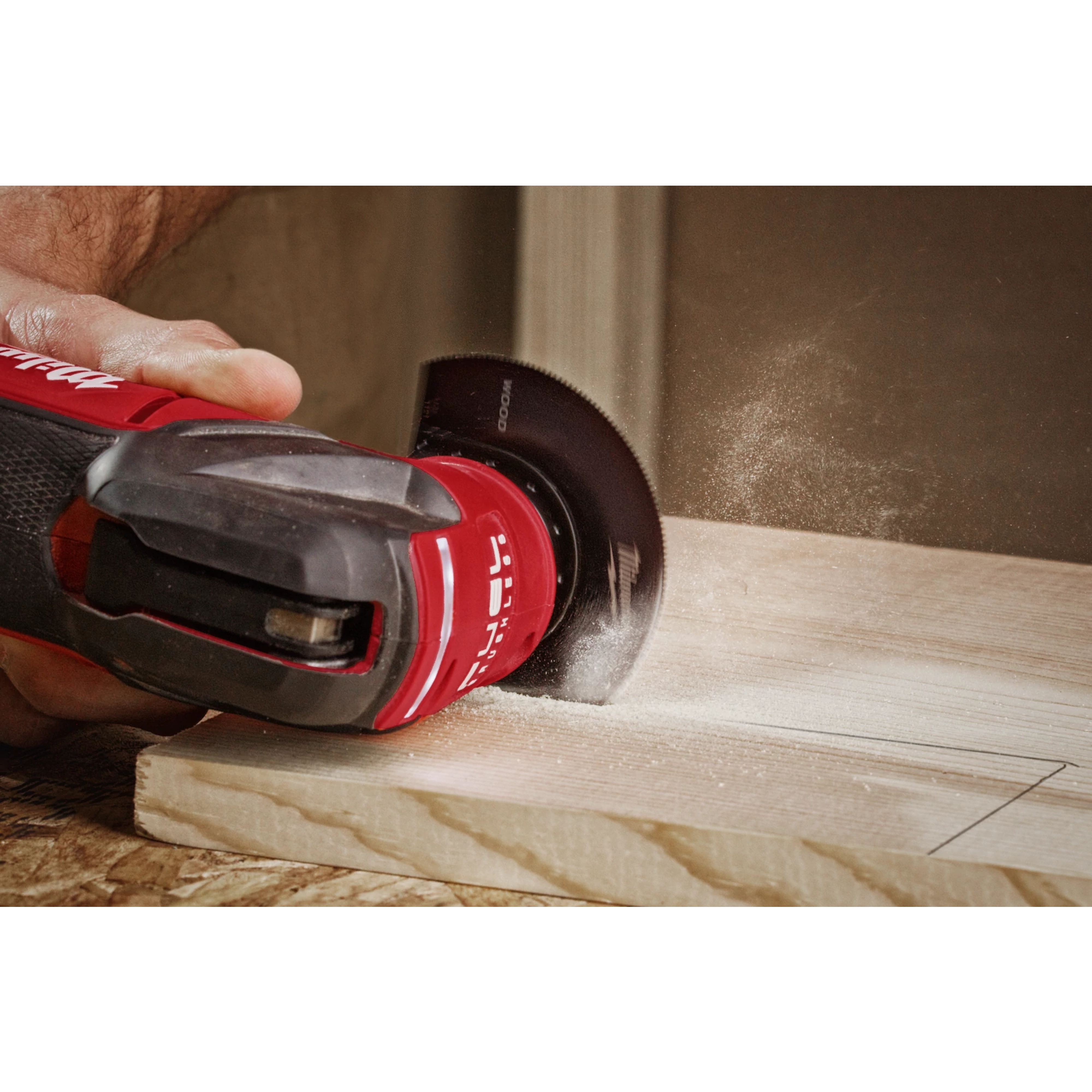 A person uses the MILWAUKEE OPEN-LOK 3-1/2" HCS Wood Segmented Multi-Tool Blade on a piece of wood, creating sawdust.