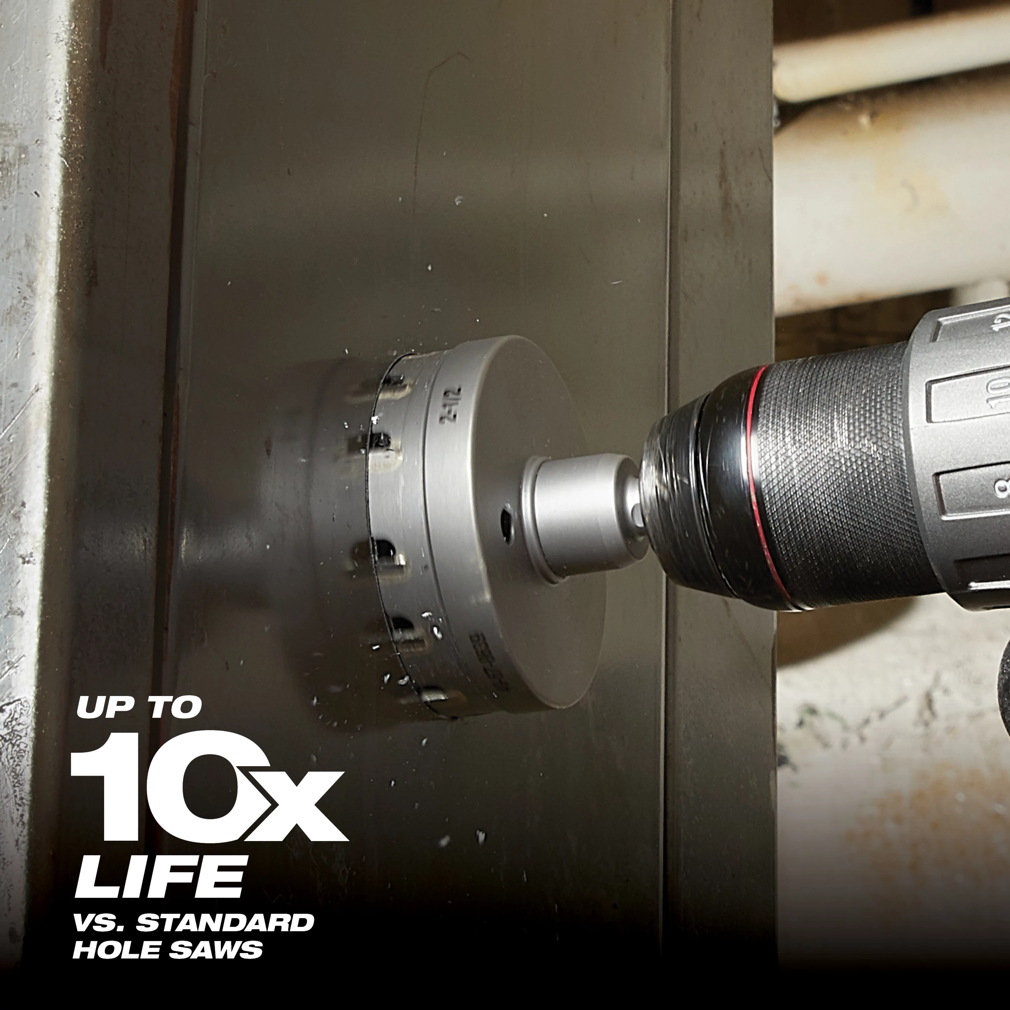 The Large Hole Cutter is attached to a power drill and is cutting through a steel surface. The image highlights that this tool offers up to ten times longer life compared to standard hole saws. The tool is cylindrical with sharp teeth around the edge for effective cutting.