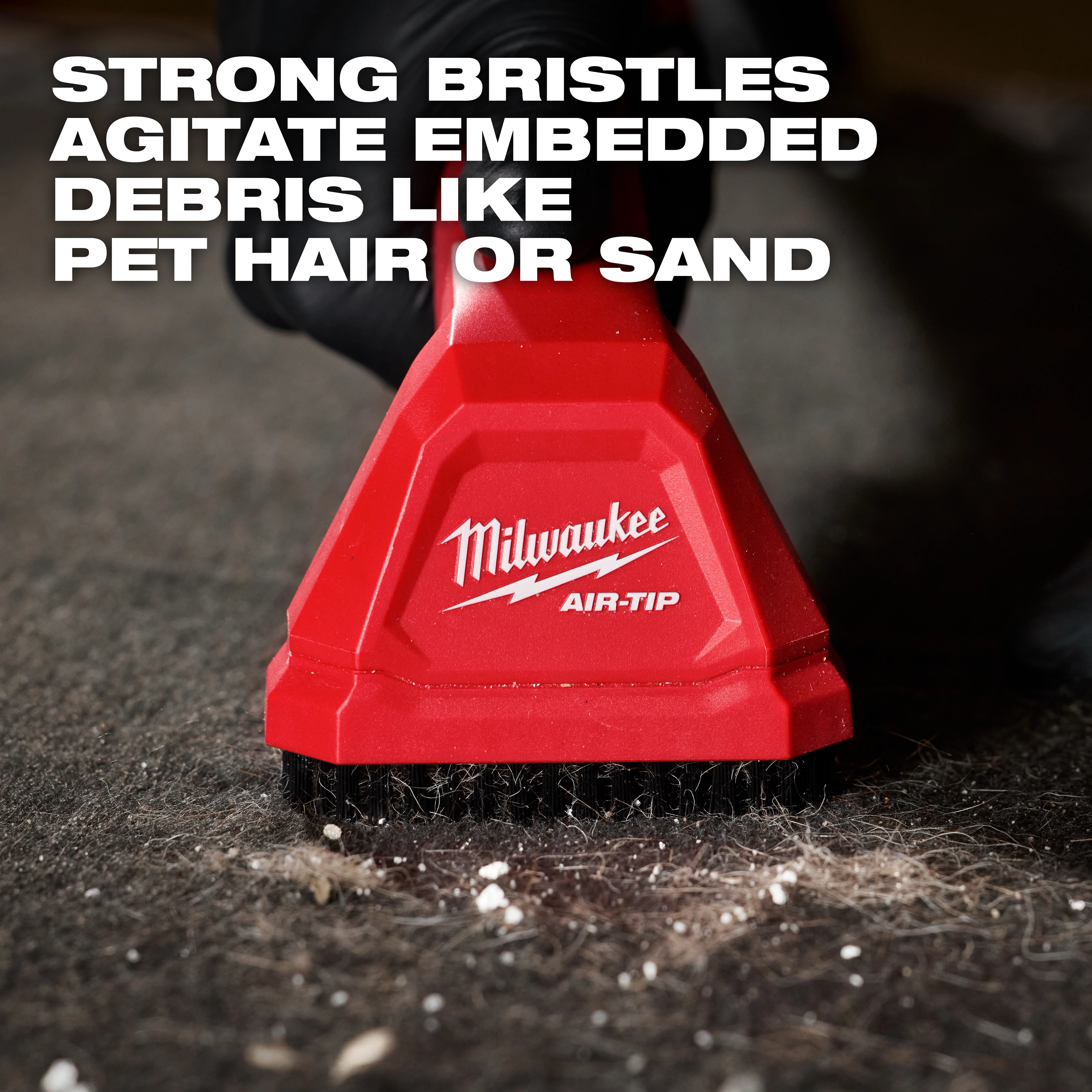 AIR-TIP Automotive Detail Brush with strong bristles shown cleaning embedded debris like pet hair or sand from a surface.