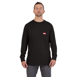 A man wears a Heavy-Duty Pocket T-Shirt in black with a red logo tag on the chest pocket. He is also wearing gray pants.