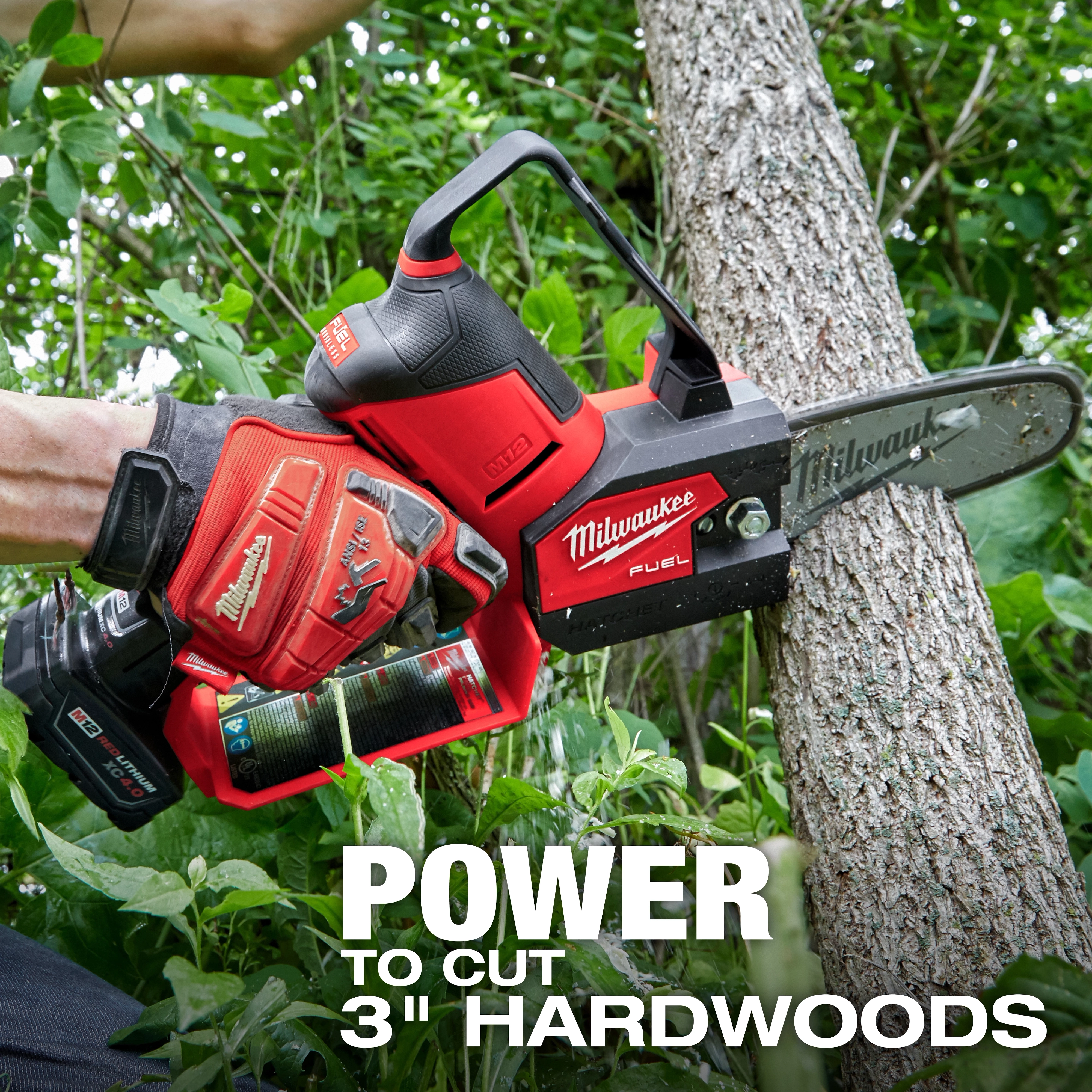A person uses an M12 FUEL™ HATCHET™ 6" Pruning Saw to cut through a tree branch. The image highlights the tool's power to cut through 3" hardwoods. The saw and the person's glove are branded with Milwaukee logos.