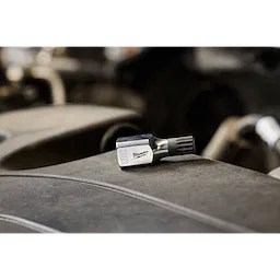 3/8" Drive 12mm Triple Square Bit Socket with engraved label lies on a dusty surface in an industrial setting.